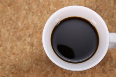 beyaz bir porselen fincan siyah kahve, mantar platemats üzerinde