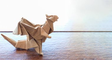 bir model origami ejderha ağır kahverengi kağıttan yapılmış, ahşap bir masa üstü