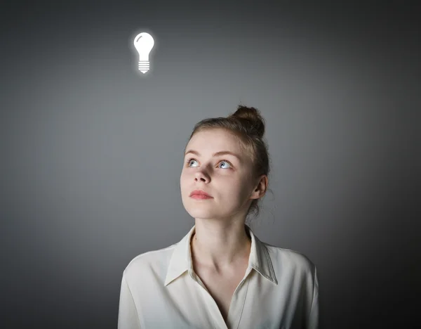 Girl in white and light bulb — Stock Photo, Image