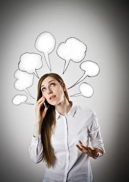 Woman in white with telephone and blank speech bubbles over her — Stock Photo, Image