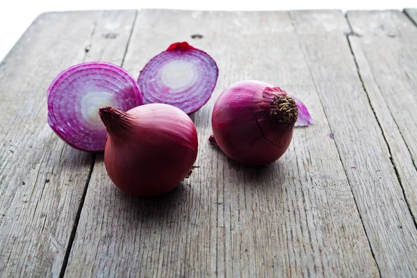 Cibule na dřevěný stůl — Stock fotografie