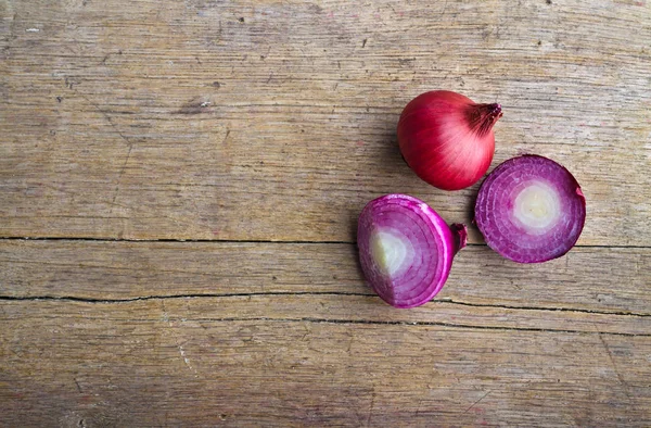 Onions on wooden table — Stock Photo, Image