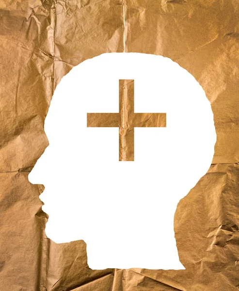 Papel enrugado em forma de cabeça humana e sinal de mais no pa dourado — Fotografia de Stock