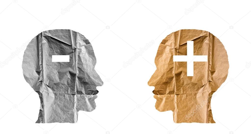 Crumpled paper shaped as a human heads and plus and minus signs.