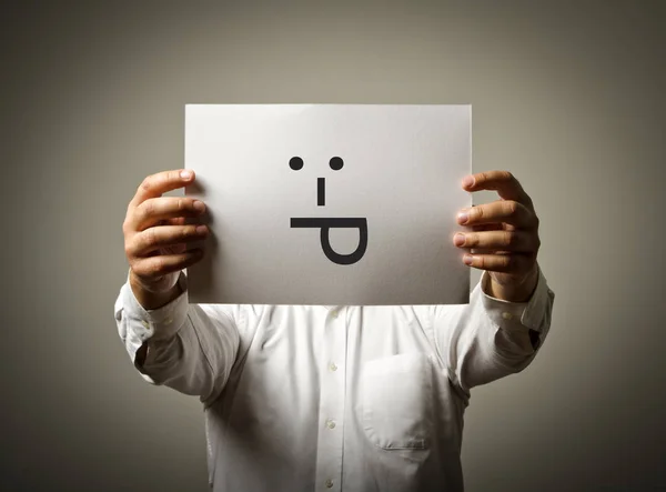 O homem está segurando papel branco com sorriso. Língua para fora conceito . — Fotografia de Stock