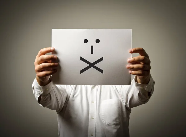 O homem está segurando papel branco com sorriso. Lábios selados . — Fotografia de Stock