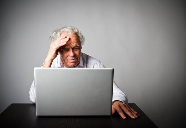 старый человек с помощью ноутбука
