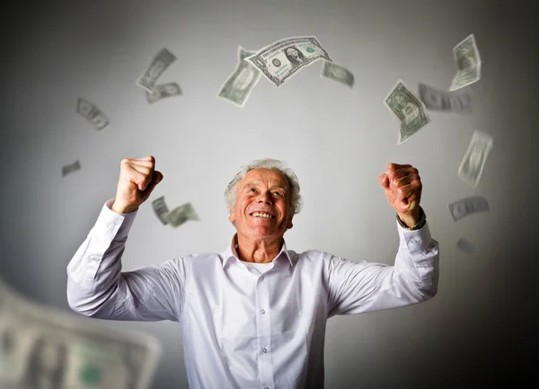 Oude man in de witte en dalende dollar biljetten — Stockfoto