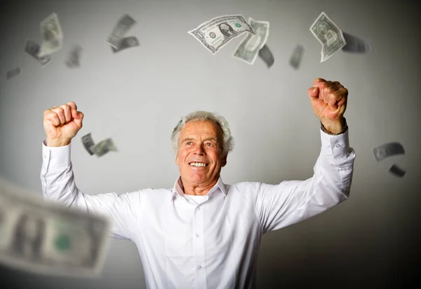 Homem velho feliz em notas brancas e em queda de dólares — Fotografia de Stock