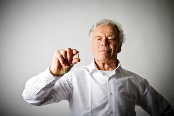 Old man in white and pill. — Stock Photo, Image