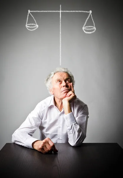 Old man is full of doubts and hesitation. Scales. — Stock Photo, Image