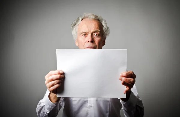 Velho está segurando papel branco . — Fotografia de Stock