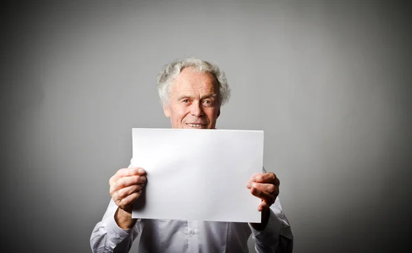 Velho está segurando papel branco . — Fotografia de Stock