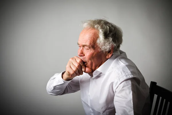 Old man in white is coughing — Stock Photo, Image