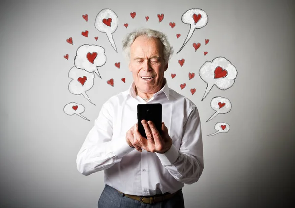 Oude man en slimme telefoon. Dag van de Valentijnskaart. — Stockfoto