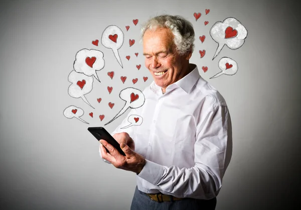 Oude man en slimme telefoon. Dag van de Valentijnskaart. — Stockfoto