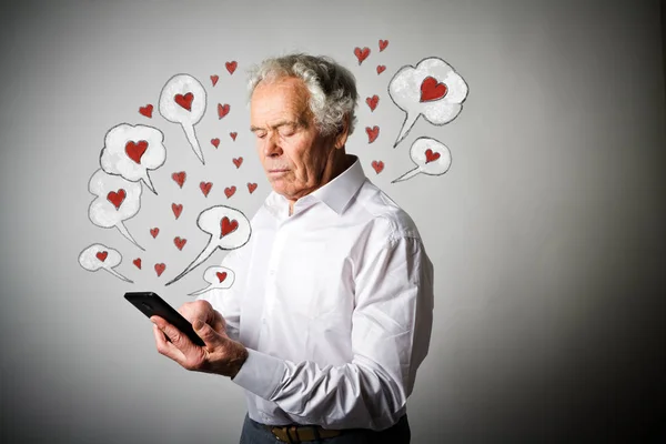 Oude man en slimme telefoon. Dag van de Valentijnskaart. — Stockfoto