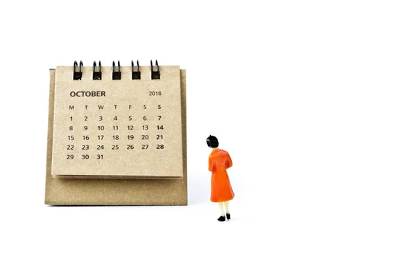 Octubre. Hoja de calendario y mujer de plástico en miniatura en bac blanco — Foto de Stock