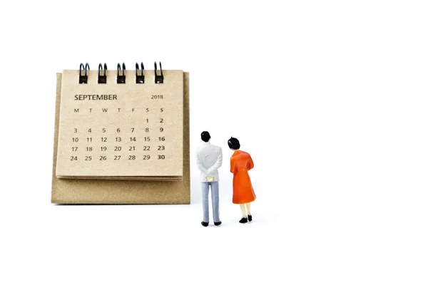 Září. Kalendář list a miniaturní plastové muž a žena na bílém — Stock fotografie