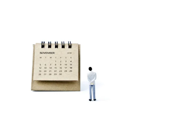 Novembre. foglio di calendario e miniatura uomo di plastica sul retro bianco — Foto Stock