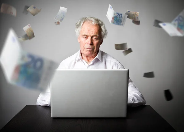 Oude man met behulp van een laptop. Oude man in het wit verdient Euro op de inter — Stockfoto