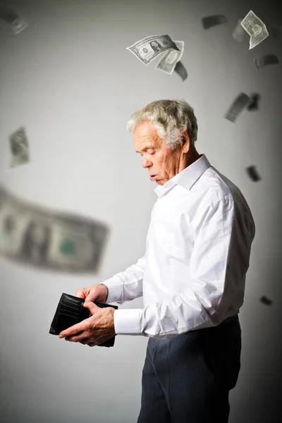 Oude man in wit en lege portemonnee. Dalende dollar en belastingen. — Stockfoto