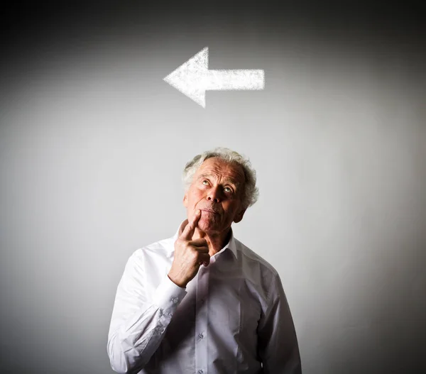 Alter Mann in weiß und Pfeil. Ein-Richtung-Konzept. — Stockfoto