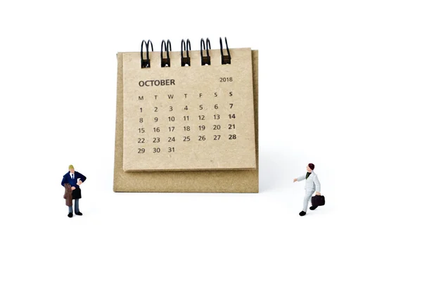 Oktober. Kalender för balansräkningen och miniatyr plast affärsmän på whi — Stockfoto