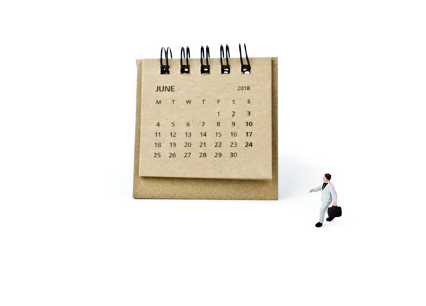 Джун. Календарь и миниатюрный пластиковый бизнесмен на белом — стоковое фото