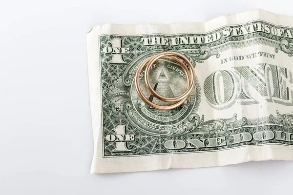 Two wedding rings and currency. Wedding or divorce concept.