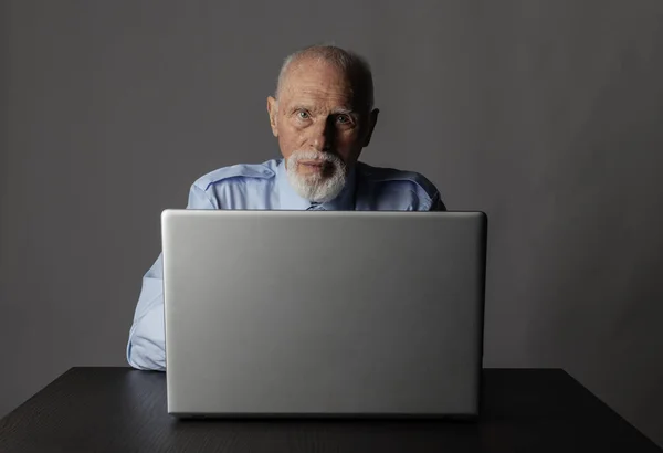 Homem velho usando um laptop — Fotografia de Stock