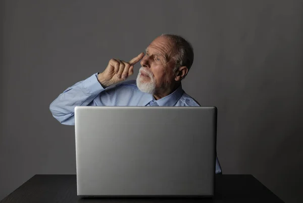 Oude man met behulp van een laptop — Stockfoto