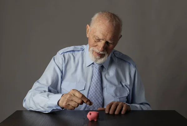 Oude man met spaarvarken. Economie en besparingen. — Stockfoto