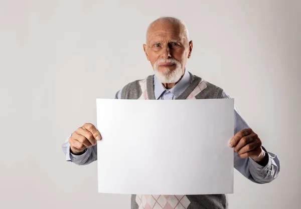 Le vieil homme tient du papier blanc . — Photo