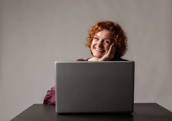 Rödhårig kvinna med laptop. — Stockfoto