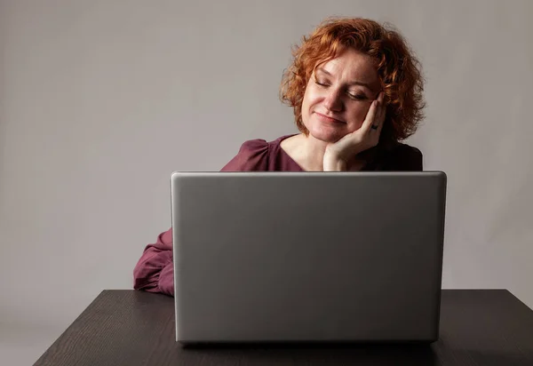 Roodharige vrouw met laptop. — Stockfoto