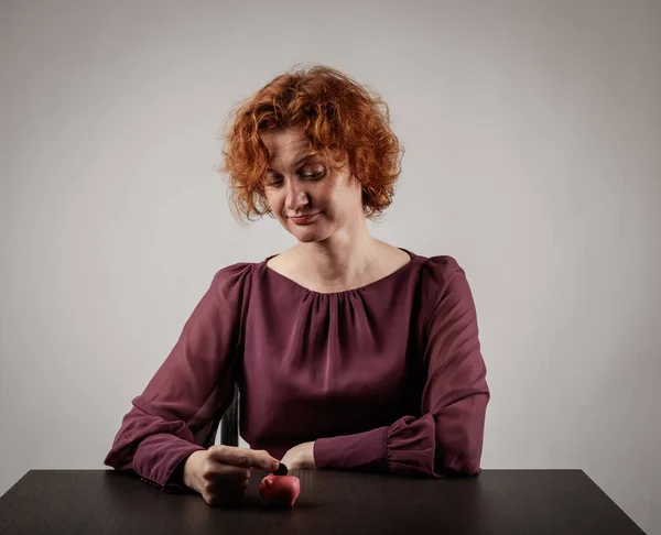 Red-haired woman and piggy bank. — Stock Photo, Image