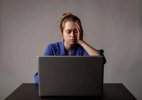 Jonge vrouw in blauw met laptop. — Stockfoto