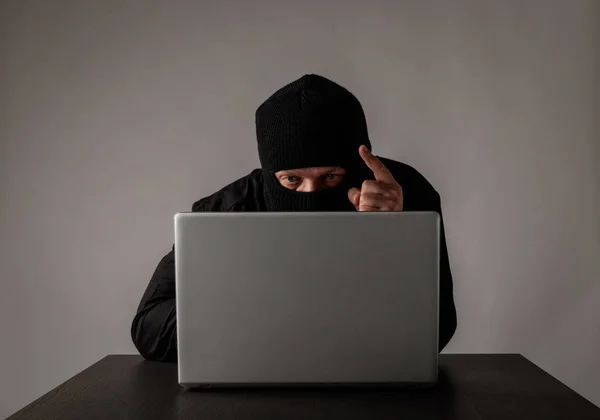 Hacker mit Laptop maskiert. — Stockfoto