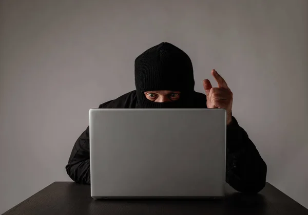 Hacker în mască folosind un laptop . — Fotografie, imagine de stoc
