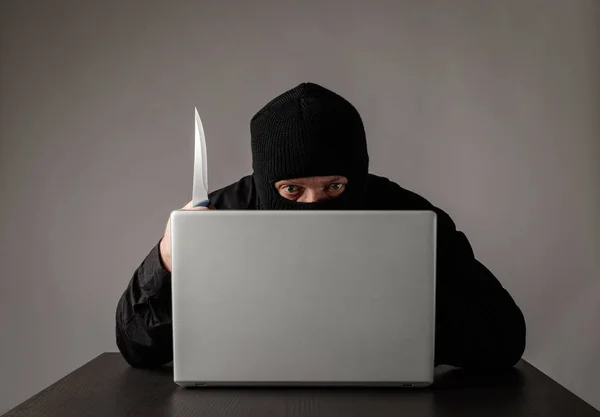 Haker w masce przy użyciu laptopa. — Zdjęcie stockowe