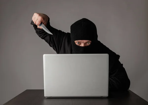 Hacker i mask med hjälp av en bärbar dator. — Stockfoto