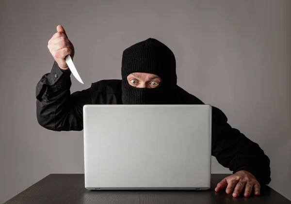 Hacker in masker met behulp van een laptop. — Stockfoto