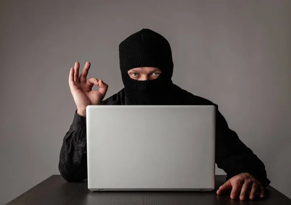 Hacker mit Laptop maskiert. — Stockfoto