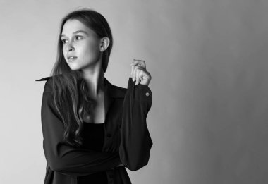 Gri arka planda mavi elbiseli çekici bir kadın. Siyah beyaz resim.