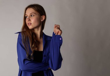 Young attractive woman in blue on gray background.