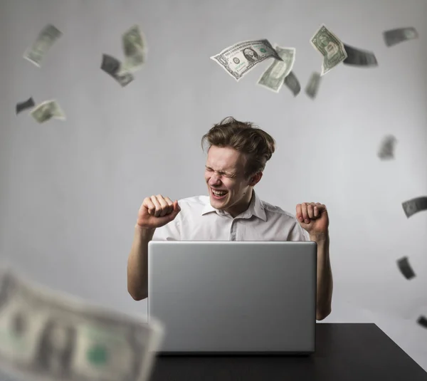 Giovane uomo felice con computer portatile e banconote da un dollaro in caduta. Successo — Foto Stock