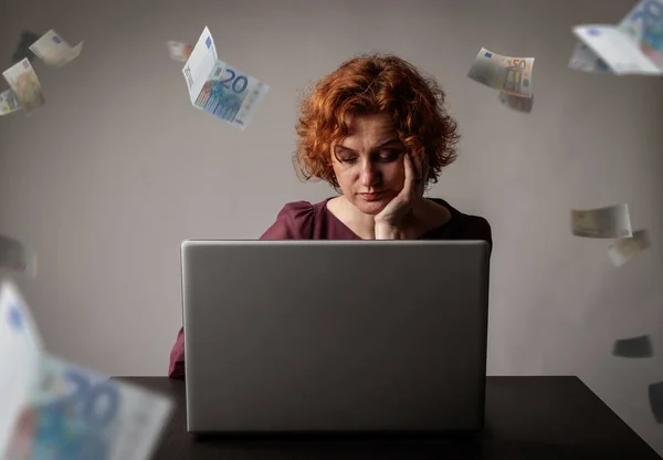 Vörös hajú nő laptoppal. Piros hajú nő és csökkenő euró — Stock Fotó