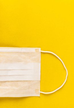 Sarı arka planda tıbbi koruyucu maske. Cerrahi maske. Çin coronavirüs salgını kavramı.