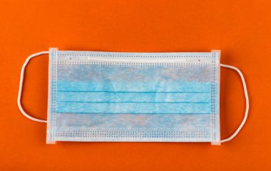 Turuncu arka planda tıbbi koruyucu maske. Cerrahi maske. Çin coronavirüs salgını kavramı.